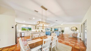 A spacious kitchen with a dining area, a large window, and a round mirror. - Sombrero Sanctuary ~ Pet Friendly Pool Home, Steps to the Beach! (Marathon)