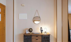 Ein Holzkabinett mit einem Globus, einer kleinen Statue und einer Lampe darauf.