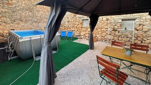 An outdoor patio with a pool, chairs, and a table. - Casa Valdebek with Pool, Pula, Croatia (Pula)