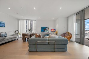 A modern living room with a sofa, dining table, and artwork. - 海滨CBD/奢华2室/可住6人/海港大桥/悉尼歌剧院 (Barangaroo)