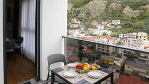 A balcony with a table set for breakfast, overlooking a residential area with houses and greenery. - La Dimora Azzurra 103, Vlore, Albania (Vlore)
