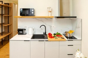 A modern kitchen with a microwave, coffee maker, sink, and a cutting board with vegetables. - La Dimora Azzurra 102, Vlore, Albania (Vlore)