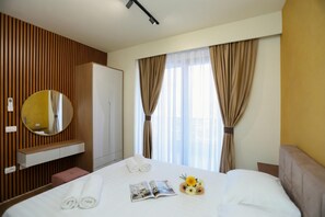 A hotel room with a bed, a bedside table, a mirror, a wardrobe, and a window with curtains. - La Dimora Azzurra 102, Vlore, Albania (Vlore)