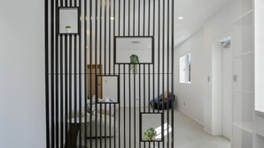 A hallway with a black vertical partition, a white door, and a small potted plant. - Spacious 5BR House for 14ppl/Family Gathering/Park (Kingsgrove)