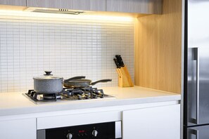 Een koelkast, een oven, een broodrooster, een eettafel