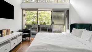 A bedroom with a bed, a desk, a chair, and a sliding glass door to a balcony. - Leichhardt 3-Level Family House | Near CBD (Leichhardt)