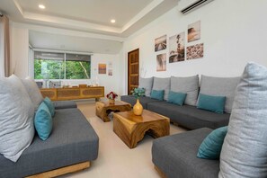 A modern living room with grey sofas, wooden coffee table, and wall art.