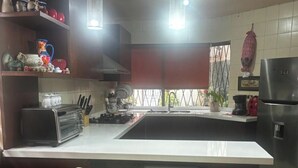 A kitchen with a central island, two bar stools, a toaster, and a refrigerator. - World Cup House. 10 Min to Stadium. BBVA & Cerro View (Guadalupe)
