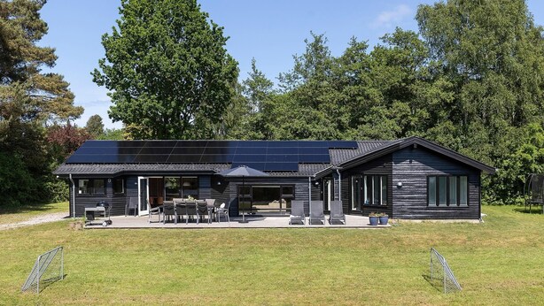 A modern house with a solar panel roof, a covered patio with outdoor furniture, and a large lawn. - VillaVilla 963 - Vejby Strand, Nordsjælland (Græsted)