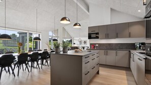 A modern kitchen with a central island, dark cabinetry, and pendant lighting. - VillaVilla 960 - Østersøbadet, Lolland/Falster/Møn (Rødby)