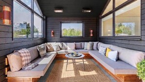 A modern interior with a sectional sofa, large windows, and a central coffee table. - VillaVilla 960 - Østersøbadet, Lolland/Falster/Møn (Rødby)