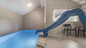 A swimming pool with a blue slide, a window with a view, and two chairs. - VillaVilla 960 - Østersøbadet, Lolland/Falster/Møn (Rødby)