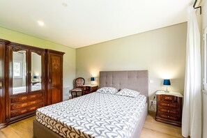 A bedroom with a bed, dresser, nightstands, and a wardrobe. - Charming Retreat with Pool (Amares)