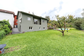 A two-story building with a flat roof, a small balcony, and a well-maintained lawn. - Charming Retreat with Pool (Amares)