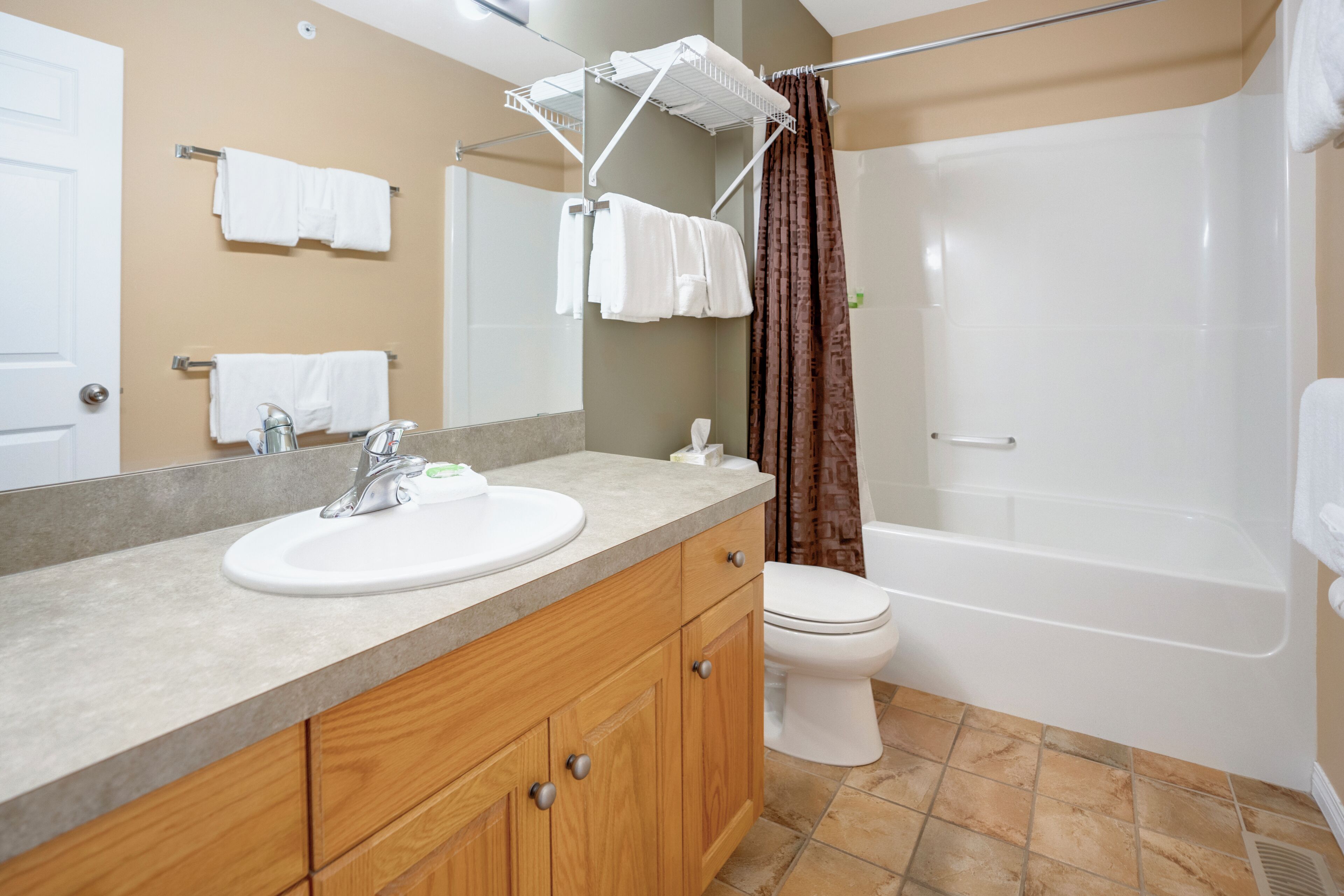 Ein Badezimmer mit Waschbecken, Spiegel, Handtuchhalter, Toilette und Badewanne.