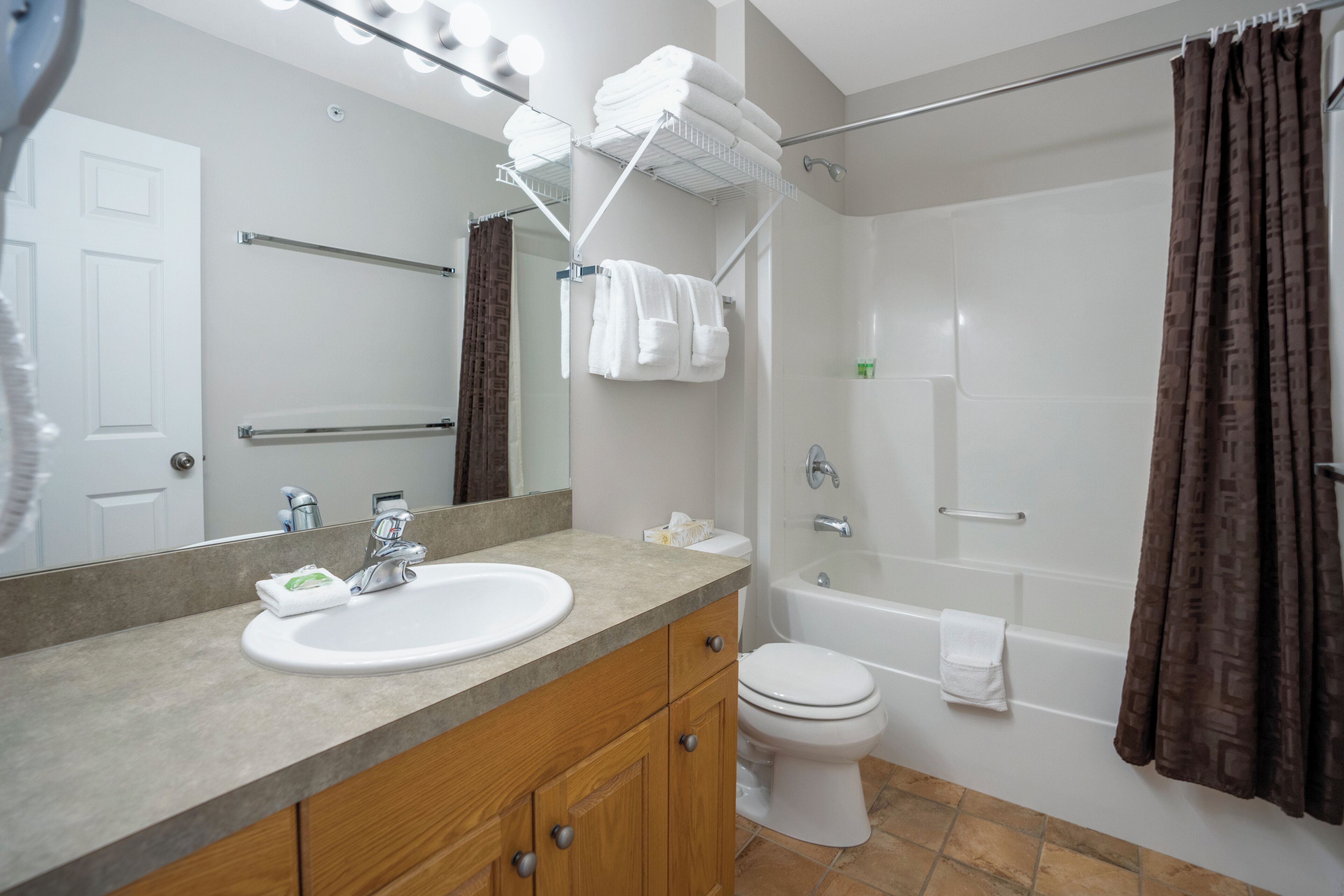 Une salle de bain équipée d’un lavabo, d’un miroir, d’un porte-serviettes et d’une baignoire.