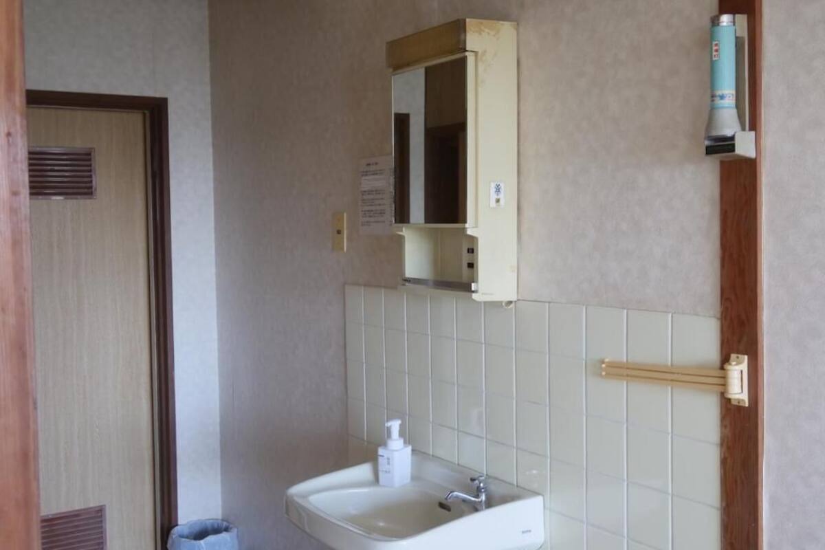 A bathroom with a sink, mirror, and towel rack.