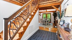 A wooden staircase with a unique design, a dining area with a view, and a reception desk. - Great Aspen Getaway | Luxury, Pet-Friendly Home with Game Room & Fire Pit! (Black Mountain)