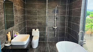 Un baño moderno con bañera, ducha, inodoro y lavamanos.