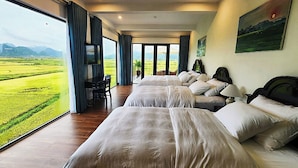 Una habitación de hotel con un ventanal grande, un escritorio y dos camas.