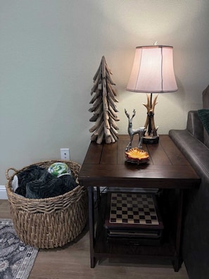 Ein Holztisch mit einer Lampe, einem Zierbaum und einem Schachbrett.