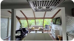 Un intérieur moderne avec un canapé, des fauteuils, une table basse et un téléviseur.
