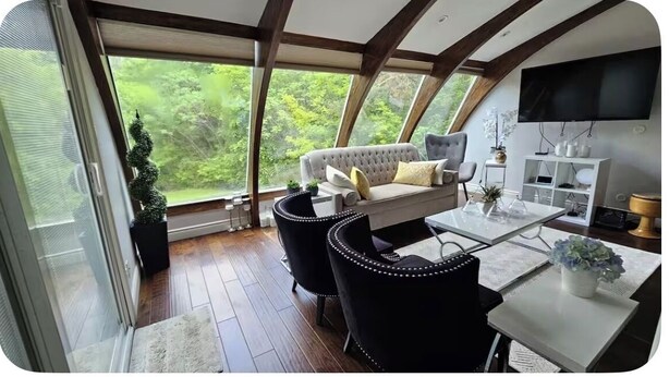 Un intérieur moderne comprenant un canapé, des fauteuils, une table à manger et un téléviseur.