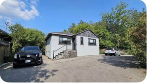 Une maison à deux étages avec un garage, une allée et un petit jardin devant.