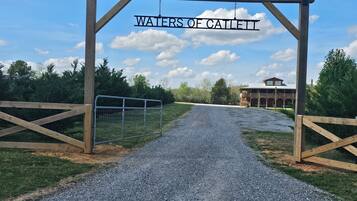 A gravel path leading to a wooden gate with a sign reading 'WATERS OF CAILETT.'