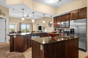 A modern kitchen with a large island, stainless steel appliances, and pendant lighting. - Spacious Table Rock Lakeview Condo Near SDC (Branson)