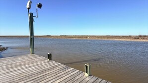 Een houten steiger die zich uitstrekt over kalm water, met een heldere lucht erboven.