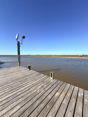 Un muelle de madera que se adentra en aguas tranquilas bajo un cielo despejado.