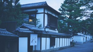 A traditional Japanese building with a tiled roof, wooden beams, and a narrow street.