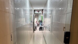 A corridor with tiled walls and a door on the right. - Private saving room for a solo traveller in Hanoi (Hà Nội)