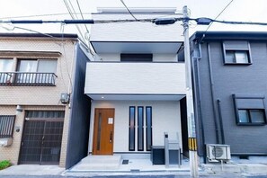 A modern two-story residential building with a flat roof, a front door, and a small porch area. - SUMISORa Osaka (Osaka)