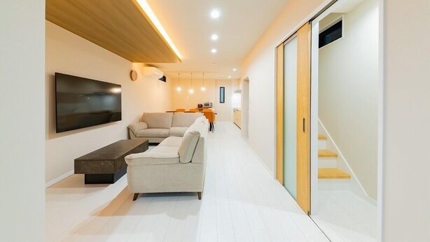 Un salon moderne avec un canapé, une table basse et un téléviseur fixé au mur.