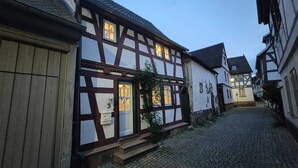 Una estrecha calle adoquinada flanqueada por casas tradicionales con entramado de madera.