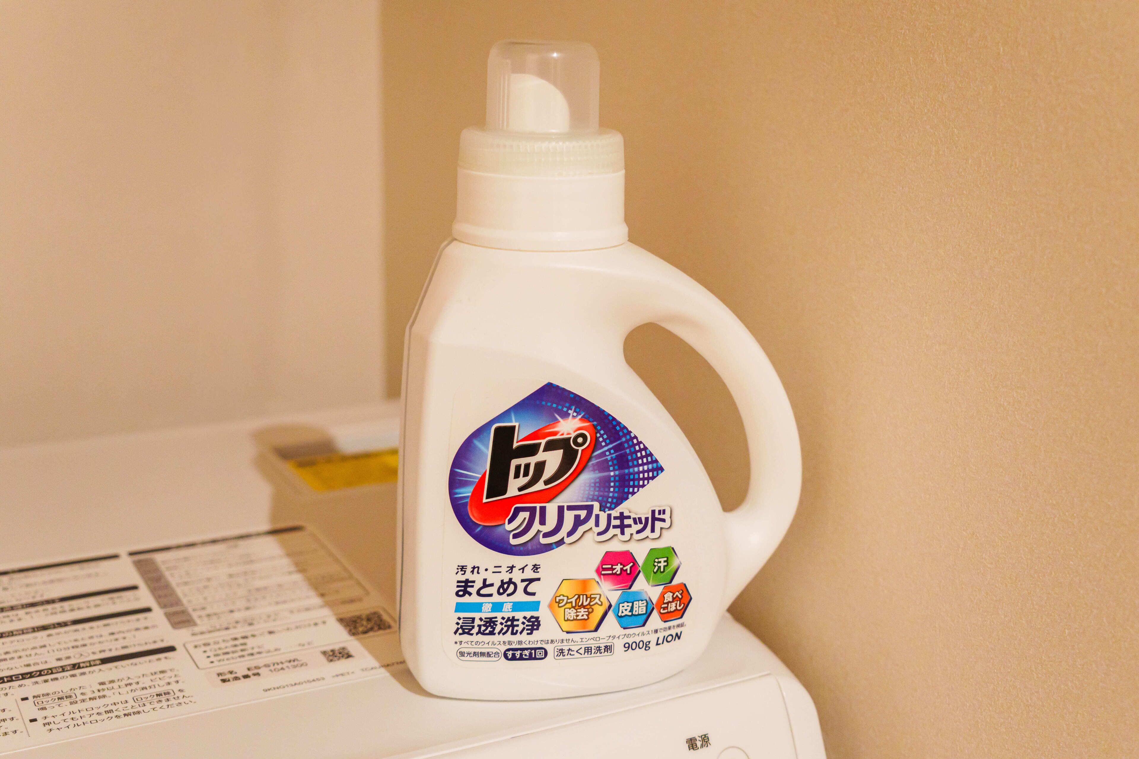 A bottle of laundry detergent on a washing machine.