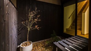 Un banco de madera, una planta en maceta y una escalera con barandilla de madera.