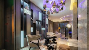 A modern interior with a sofa, chairs, a round table, and a decorative light fixture. - Crystal Hotel Shanghai Intl. Tourism (Shanghai)