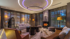 A modern living room with a sofa, armchairs, a coffee table, and a fireplace. - Crystal Hotel Shanghai Intl. Tourism (Shanghai)