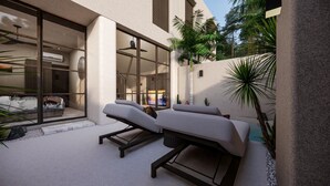 Ett modernt utomhusområde med loungekänsla, bestående av två solstolar, en glasvägg och en palm.