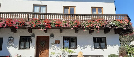 A building with a sign reading "Radlerhof" and a balcony with flowers.