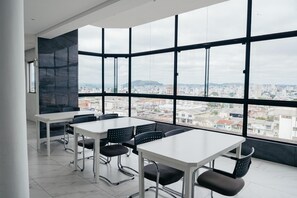 Un salón de conferencias con un amplio ventanal que da a una vista panorámica de la ciudad.
