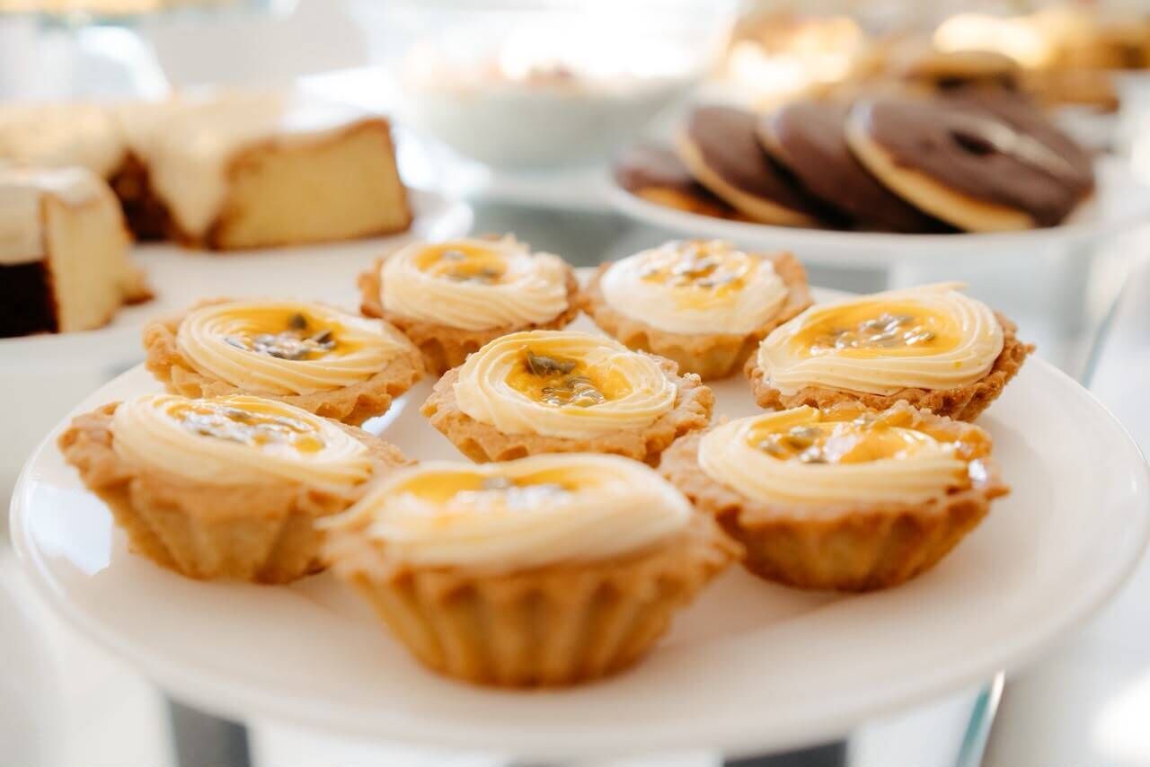 Ein Teller mit kleinen Gebäcken, bedeckt mit einer cremigen Füllung, möglicherweise Custard oder Sahne.