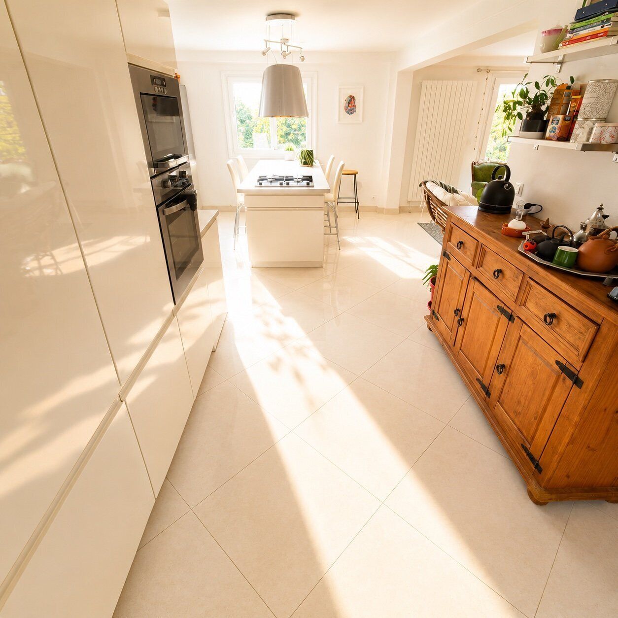 A kitchen with a central island, a wooden cabinet, and a window with blinds.