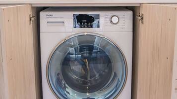 A compact washer and dryer unit installed in a kitchen cabinet.