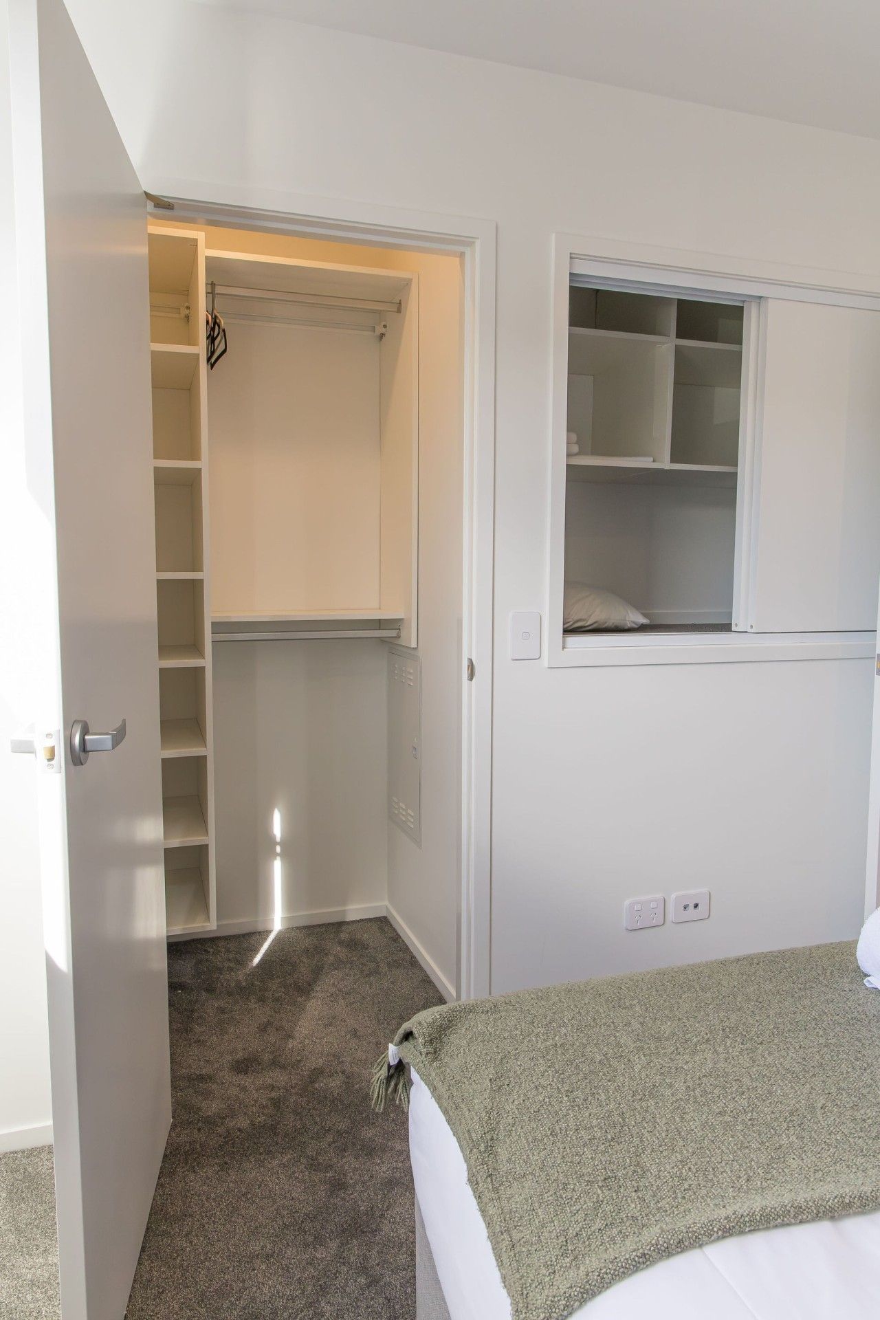 Une chambre à coucher avec un lit, une armoire et une fenêtre.