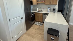 Una cucina moderna con mobili in legno, elettrodomestici in acciaio inossidabile e un piano di lavoro in marmo.