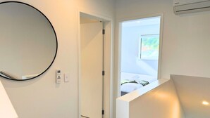 A hotel room with a large mirror, a door leading to a balcony, and a view of a bed. - Wellington Retreat with Private Courtyard (Lower Hutt)